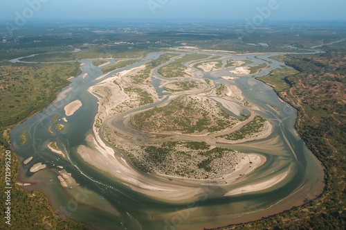 Braided rivers form islands due to swift water fluctuations, heavy sediment deposits, and unstable banks when sediment or slope exceeds a certain limit