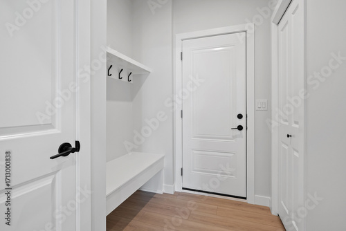 White door with a black handle and a white bench in front of it