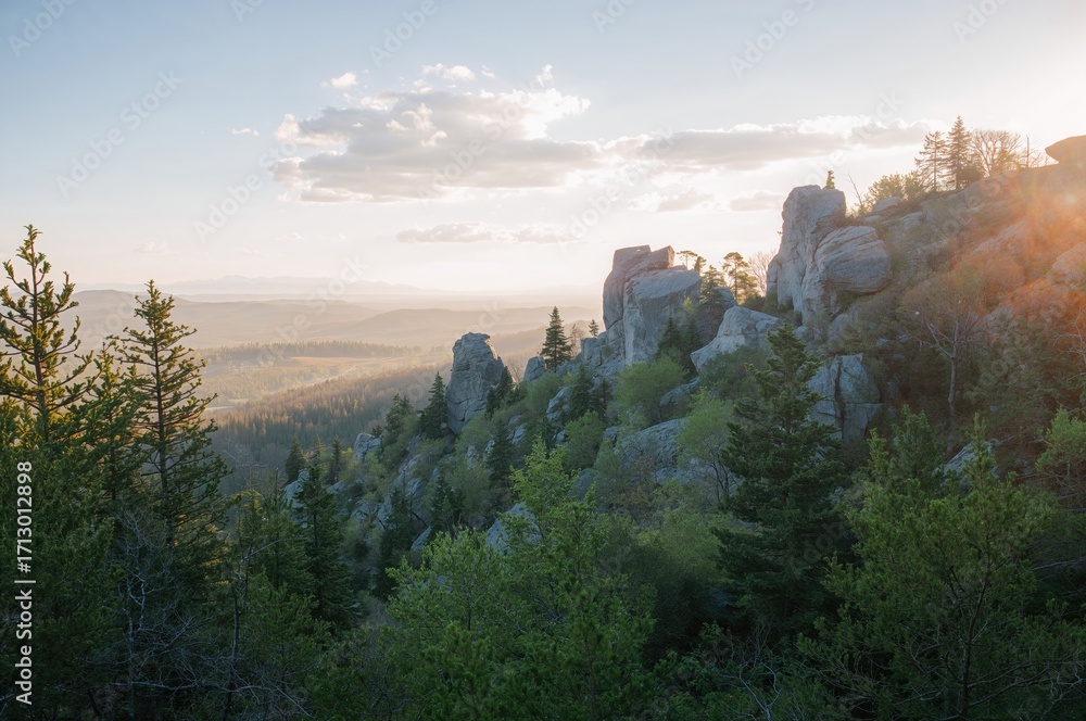Fototapeta premium Bird's-eye perspective of rugged peaks surrounded by dense pine forests