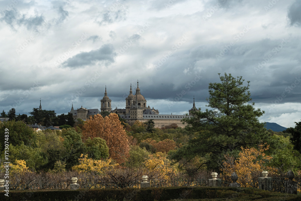 Obraz premium views of the Monastery of El Escorial and its historic gardens surrounded by autumn trees and spectacular skies.