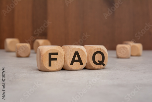 wooden cubes with the word FAQ on a table