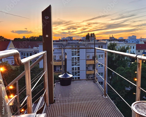 Sonnenuntergang über den Dächern Berlins vom Balkon aus orange gelber Himmel über der Stadt Berlin Skyline