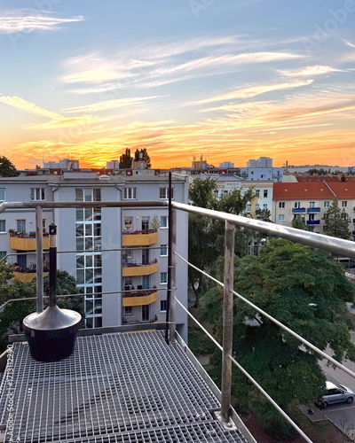 Sonnenuntergang über den Dächern Berlins vom Balkon aus orange gelber Himmel über der Stadt Berlin Skyline