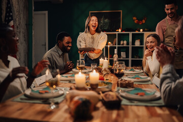 Friends laughing during thanksgiving or christmas dinner party