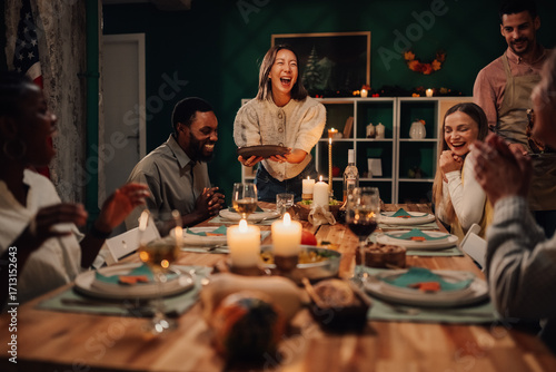 Friends laughing during thanksgiving or christmas dinner party