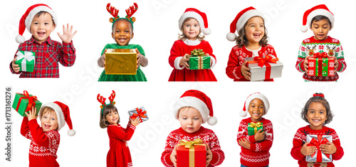 Happy toddler kids in festive Christmas sweaters and Santa hats holding colorful gift boxes isolated on transparent background, joyful holiday celebration concept for seasonal greeting and design use