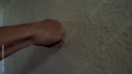 Close-up of a male fist hitting a concrete wall in a dark room 4K