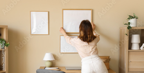 Young woman hanging blank f...