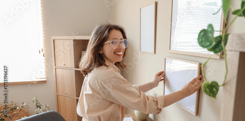 Young woman hanging blank f...
