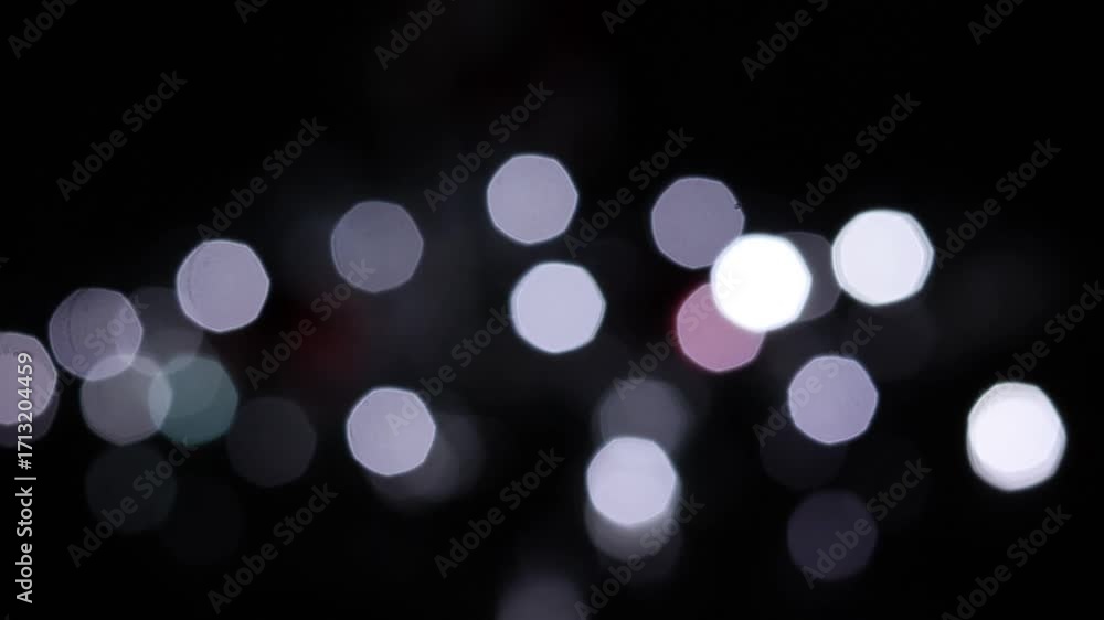 Una toma de cerca de luces de varios colores en forma de círculos en movimiento en la oscuridad. Desenfoque, efecto Bokeh. 