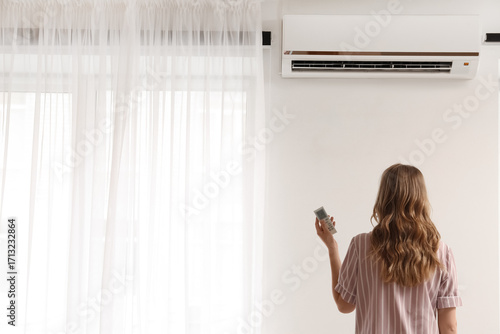 Young woman near air condit...