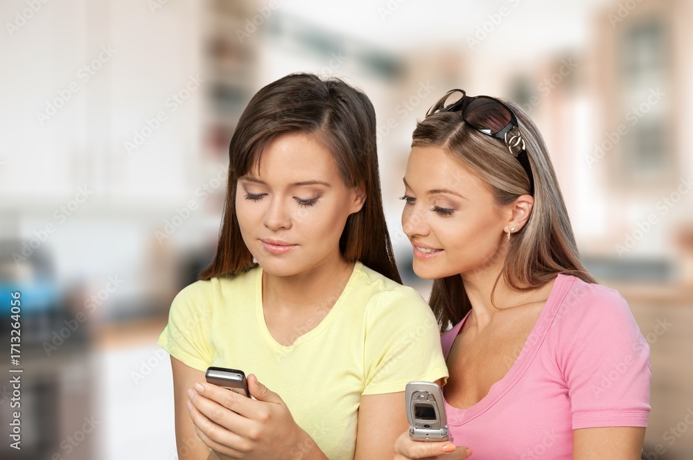 Fototapeta premium Happy young family mom with daughter using phone