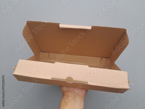 Open brown cardboard box on gray background, ready for packing or shipping