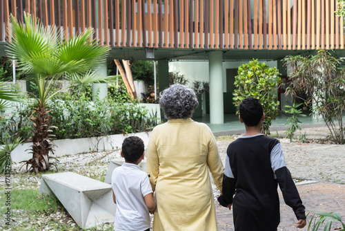 Grandmother holding hands with grandchildren walking outdoors