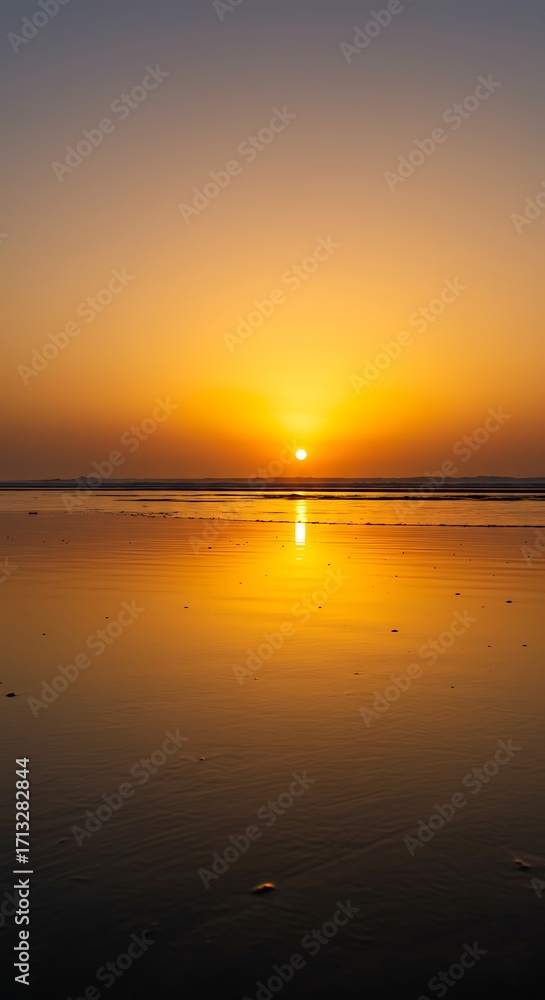 Obraz premium Golden Hour Reflection Serene Sunset Over Calm Beach Waterscape.