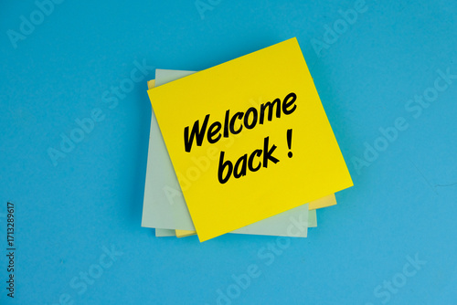 Welcome back on yellow sticky note on a pink background for your employees back to the office or college student 