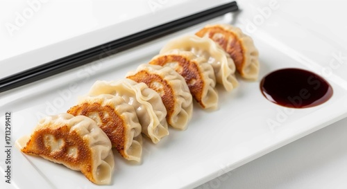 Gourmet Pan-Fried Guioza with Shoyu Sauce and Chopsticks on a Ceramic Plate