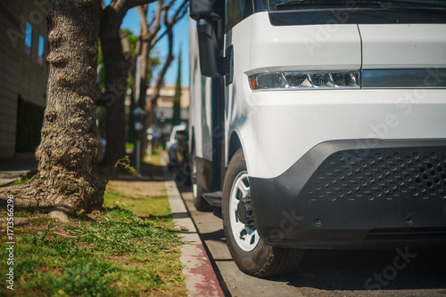 White electric truck in the city. Closeup on headlight.