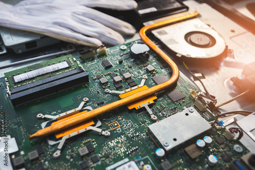 Close-up image of an all-in-one computer interior showing the motherboard, heat pipe cooling system, RAM slot, processor, and electronic components. Inside View of All-in-One Computer Motherboard