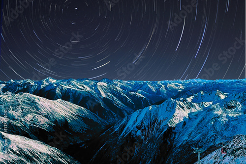 night view of snowy mountain range and milky way. starry night sky with stars and moon. beautiful landscape with snowy mountain peaks in winter night.