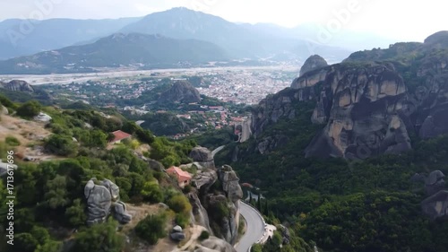 Scenic overview of mountains, unique rock formations, and a town in the distance, captured from an elevated perspective