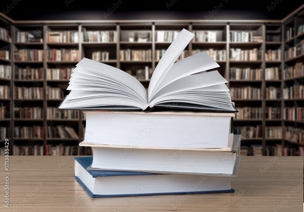 Fototapeta premium stack of books in library on wooden table
