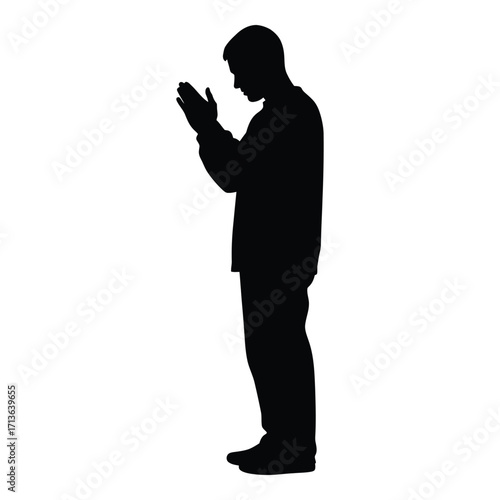 Silhouette of a man praying with hands clasped in devotion