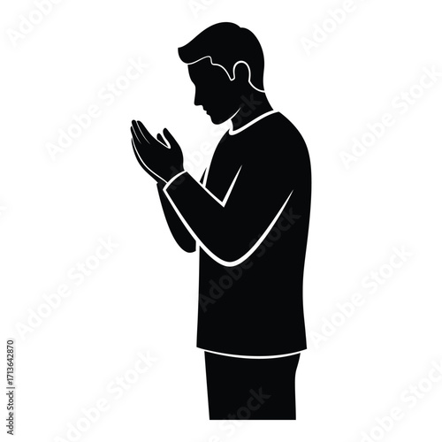 Silhouette of a man praying in supplication with hands clasped reverently