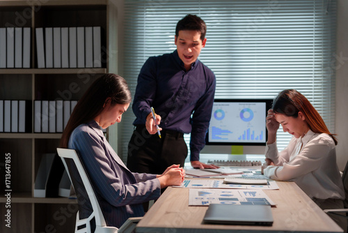 Foto Asian manager scolding two frustrated employees during a tense office meeting, h