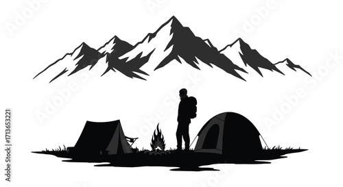Silhouette of a camper with tent and campfire before mountain range
