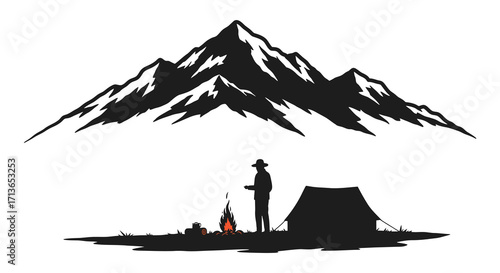Silhouette of a camper by a campfire near majestic mountains