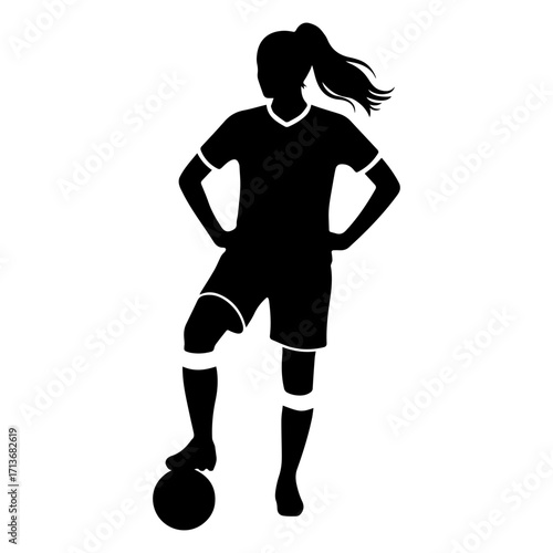 Silhouette of a female soccer player standing with foot on ball