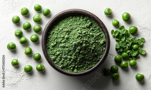 Green powder, peas, and leaves on a light surface.  A healthy food concept