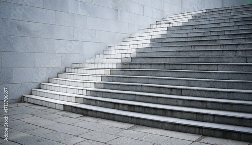 Curved stairway with alternating white and gray tiles against a light gray stone wall