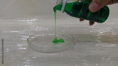Pouring Green Chemical Solution into Petri Dish in Laboratory Experiment
