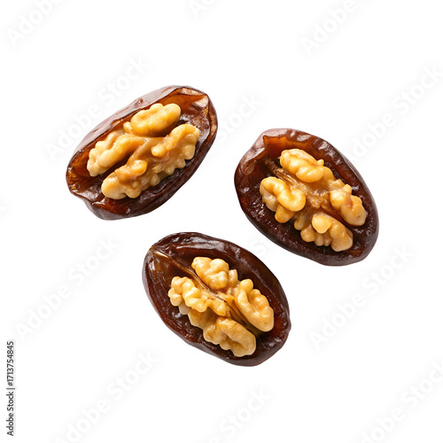 Three pitted dates stuffed with walnut halves on a black background dried fruit