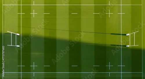 Overhead view of a rugby field with markings, goalposts, and green grass.
