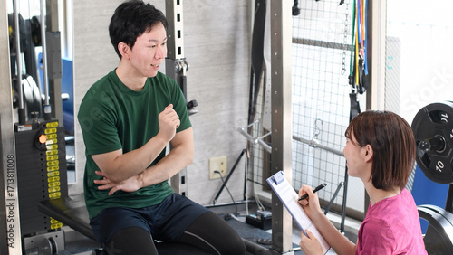 ジムで女性インストラクターと話す若い男性