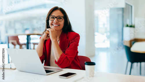 Confident businesswoman smiling while working in a bright office environment