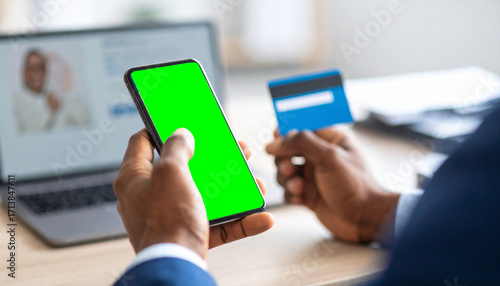 A Close-Up of an African American Man's Hands Using a Smartphone and Holding a Credit Card to Make an Online Purchase**