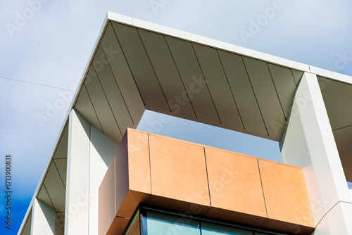 The building's façade is constructed of aluminum composite panels and HPL panels. The design is contemporary, with clean lines and contrasting colors.