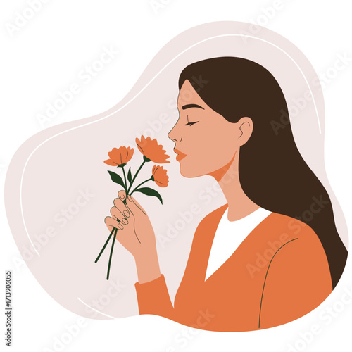Young woman smelling flowers while standing against soft background  