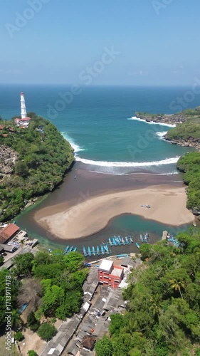 Scenic Coastal View with Lighthouse, Beach, Village, and Boats