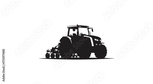 A striking black silhouette of a modern tractor with farming equipment