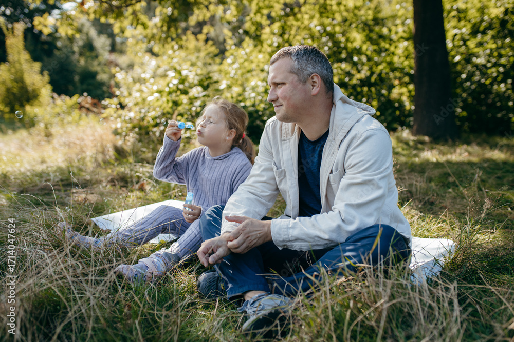 Obraz premium Adult father and little daughter are walking in the park