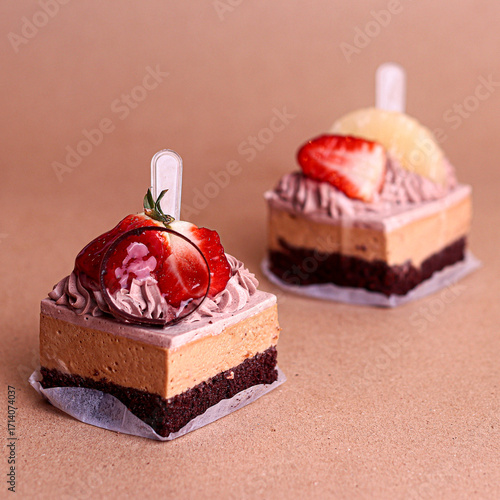 Photography Chocolate layered cake squares with cream filling topped with glossy chocolate decoration