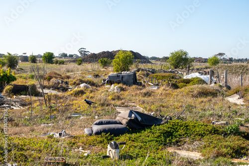 Illegal dumping of rubbish and discarded furniture in undeveloped vacant grassland at Wyndham Vale, outer Melbourne suburb,Australia. Concept of pollution, waste management, environmental damage