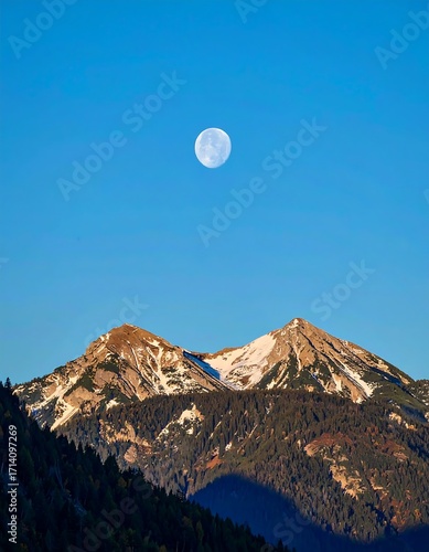 Full moon over snow-capped peaks