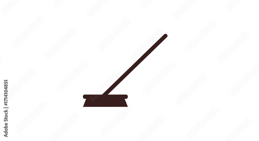 Fototapeta premium A brown broom rests on the floor with the handle angled to the right