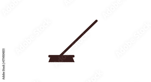 A brown broom rests on the floor with the handle angled to the right